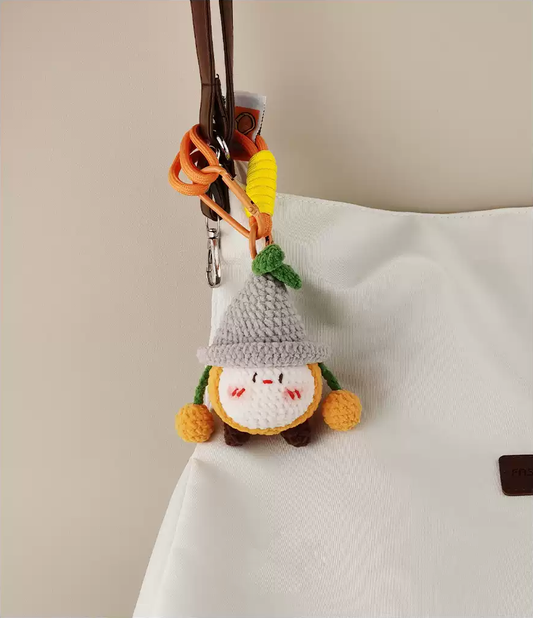 Simple and cute crochet gnome keychain, hanging on the bag with some wires, with a simple background, in a white, gray, and green color scheme, and cute expressions.