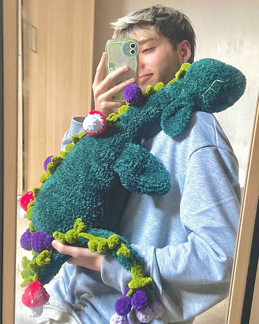 Young French artist holding his handmade amigurumi monster plush