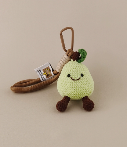 Cute, kawaii-style amigurumi green pear with brown string and tag, on a plain background.