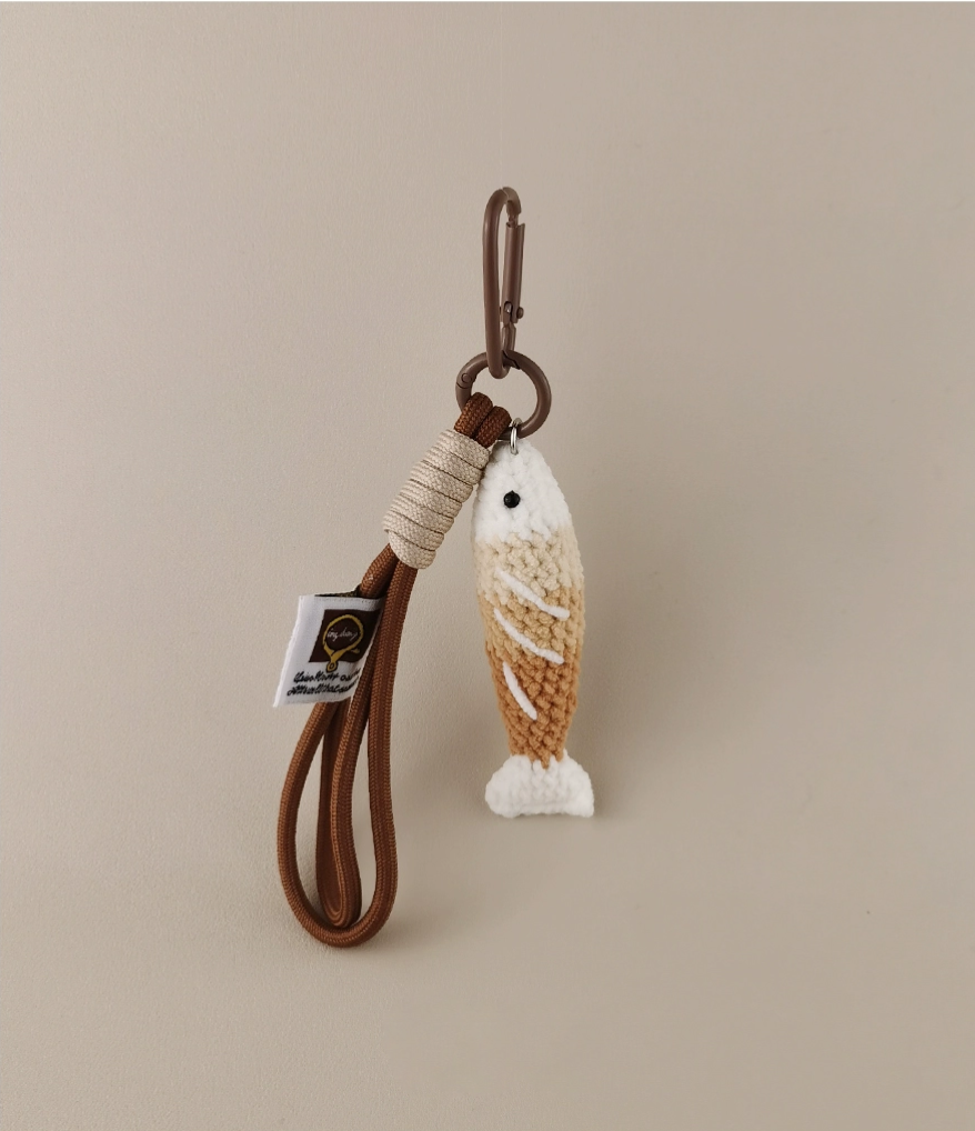 Handmade red crochet Fortune Fish keychain with a golden hanging cord and lobster clasp, displayed on a soft neutral background. A symbol of luck and abundance, inspired by the Chinese saying "年年有鱼".