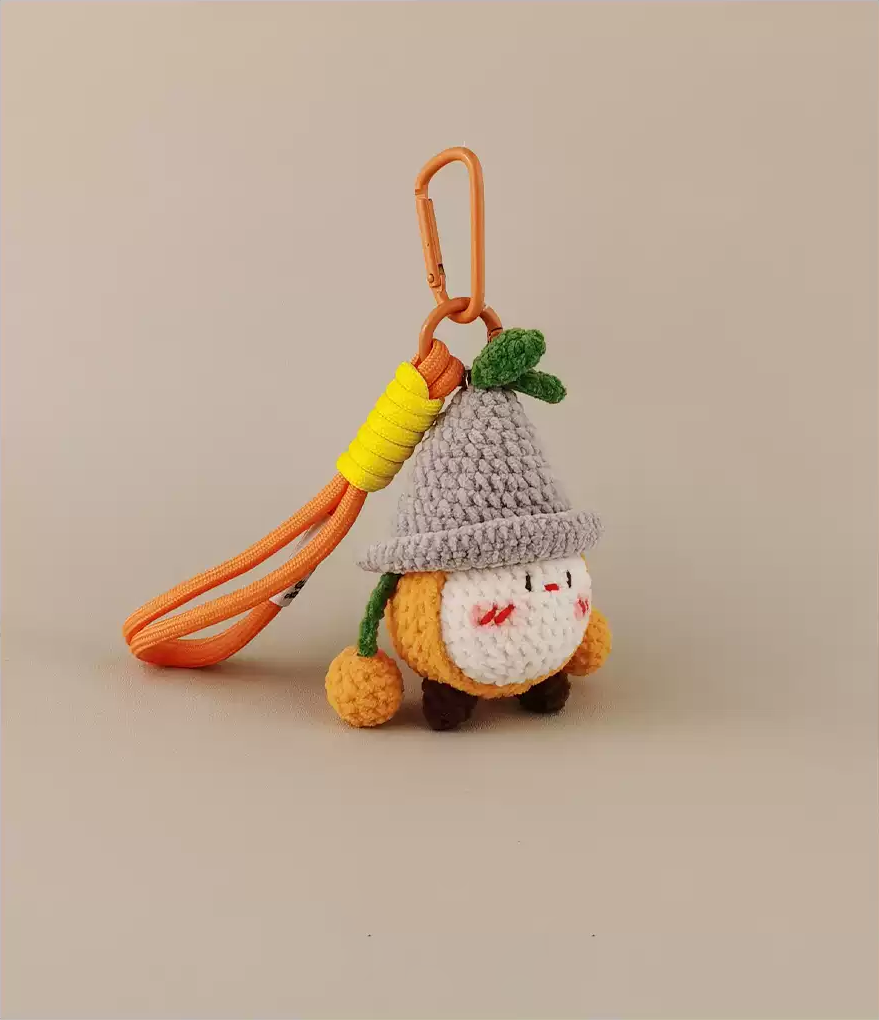  Cute crochet keychain, fruit character design, orange, yellow, and gray color scheme, white background, simple style, solid colors, woolen texture, minimal details, cartoon shape, cute expression, small hat on the head, slender body with two legs, simple leather hanging ring.